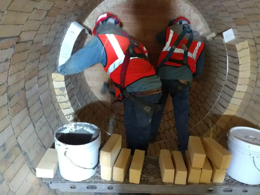 Dos técnicos colocando ladrillo refractario